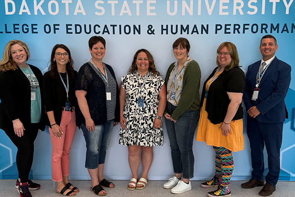 Addie Borah (far left) and Dean David De Jong (far right) pose for a photo with students in the TAP program.